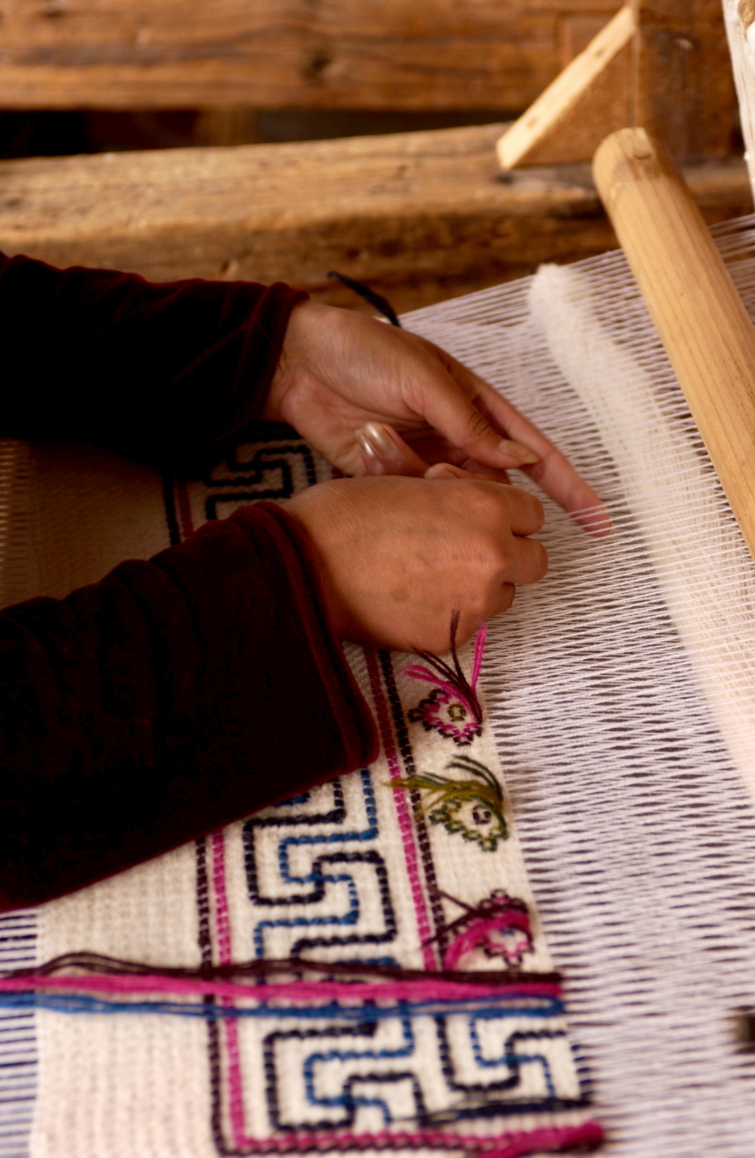 Artisan hands weaving on a loom